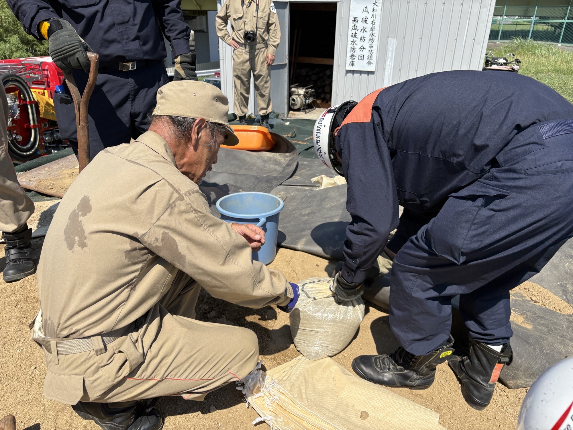 水防団と一緒に土のうを作っているところ