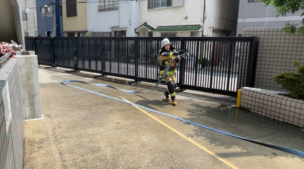ホース延長完了の報告をする隊員