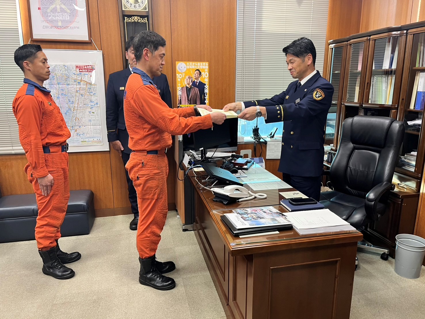 西成消防署長から表彰状を受賞する西成救助隊岡本消防司令の様子