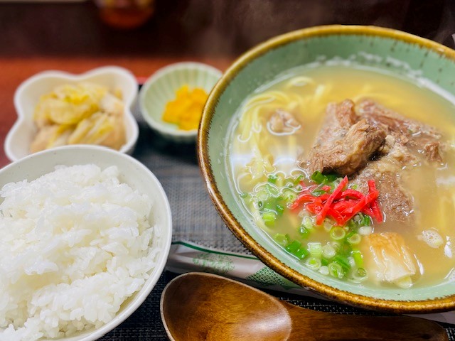 豚スペアリブがのったソーキそばとごはん、小鉢などがセットになった定食の写真