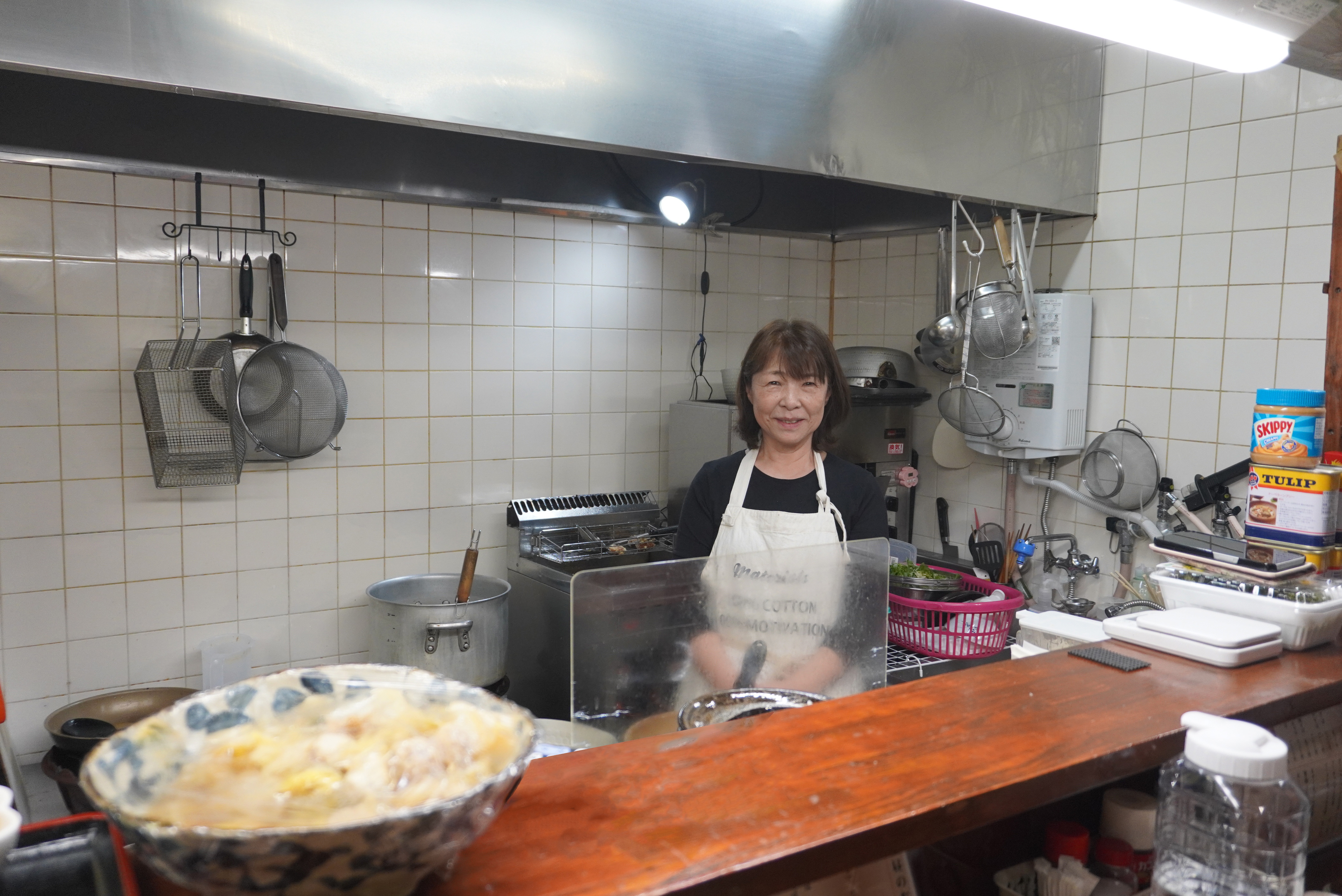 カウンター内で調理するタカコさんを撮影した写真