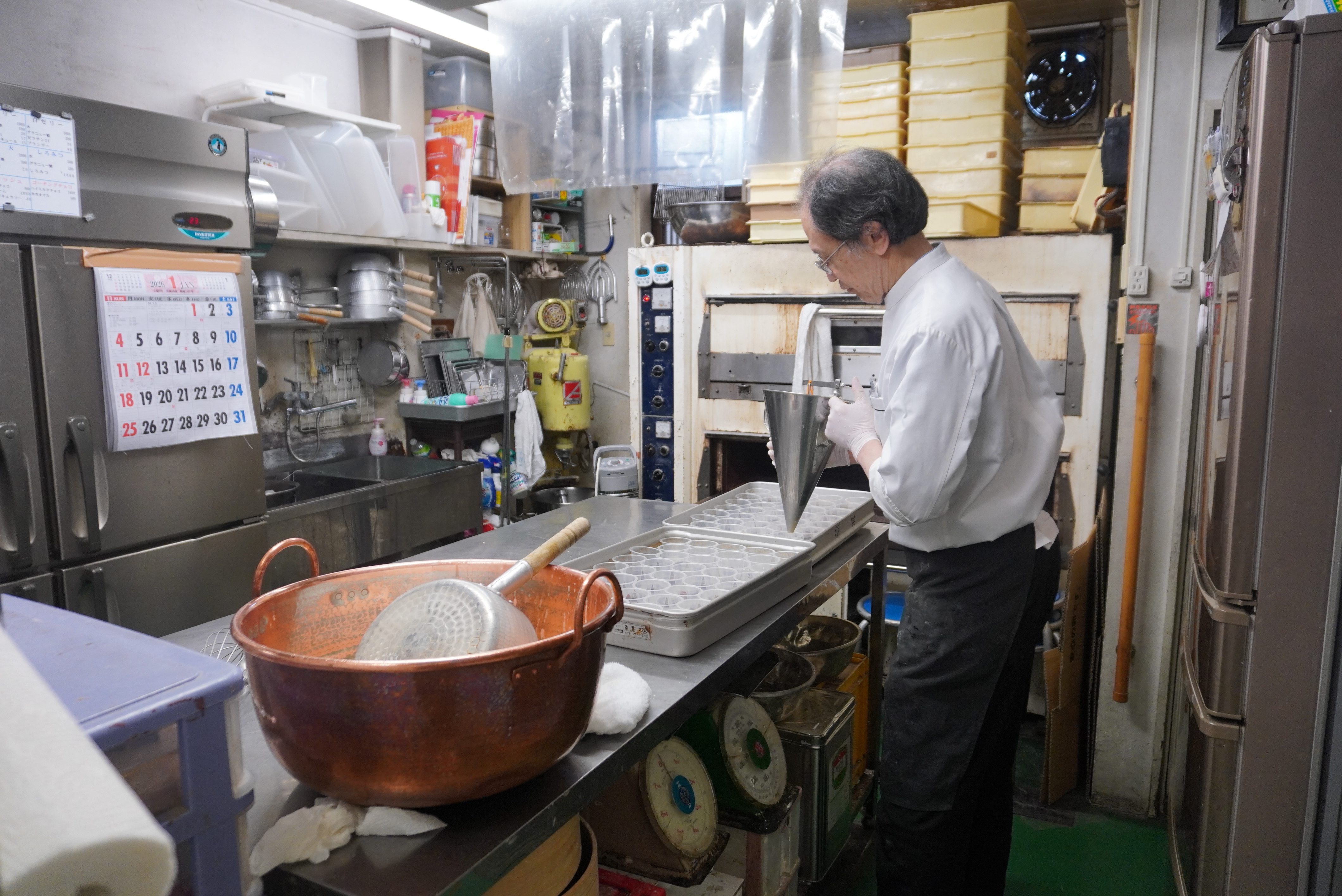 カップにプリン液を流し込んでいる様子