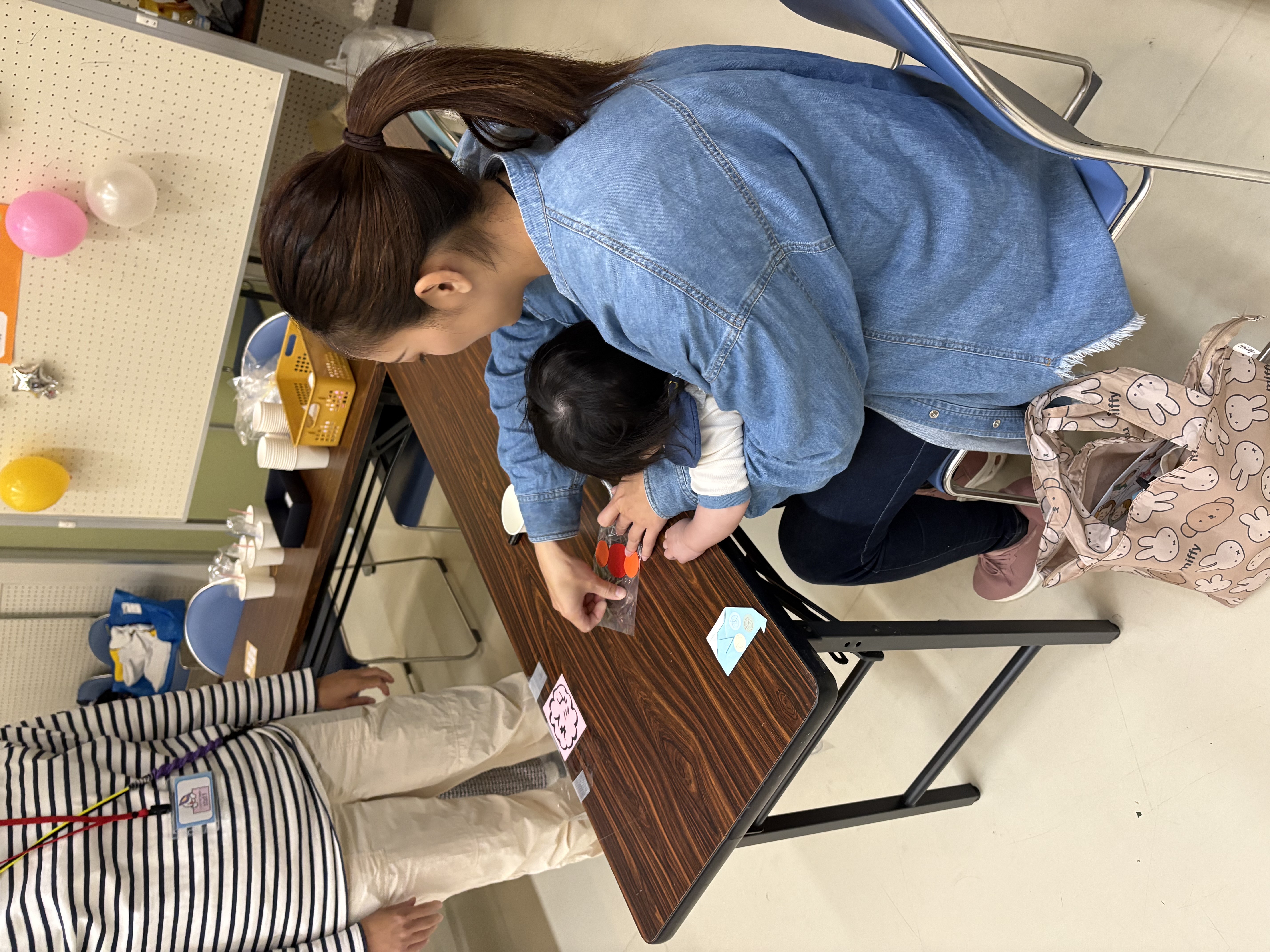 制作コーナーで、おもちゃを作っている親子