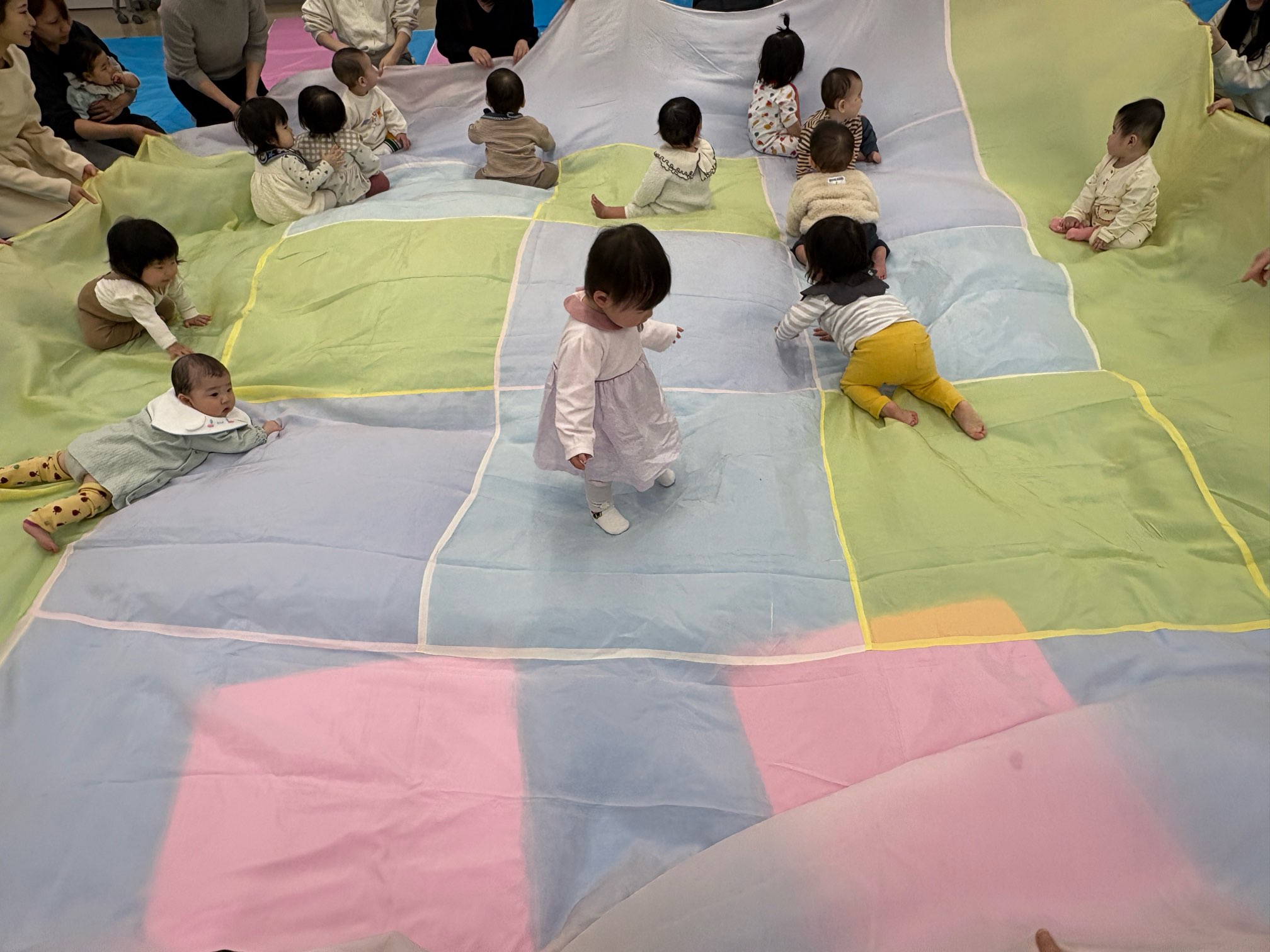 大きな布の上に乗り、遊んでいる子どもたち