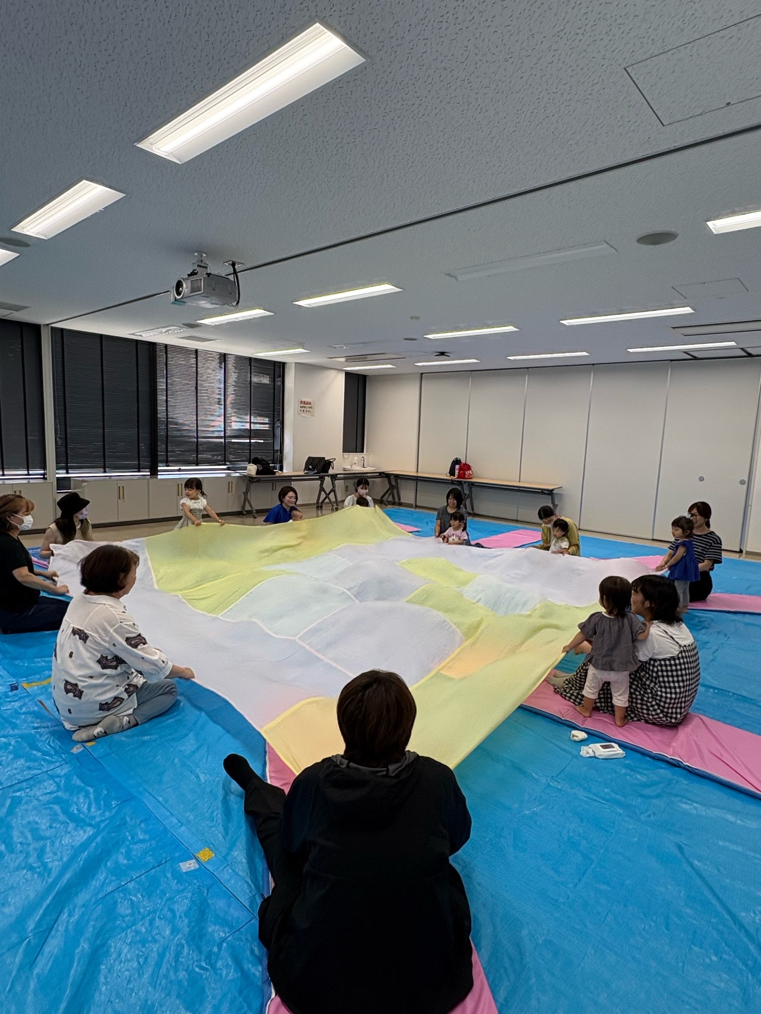 大きな布で遊んでいる親子