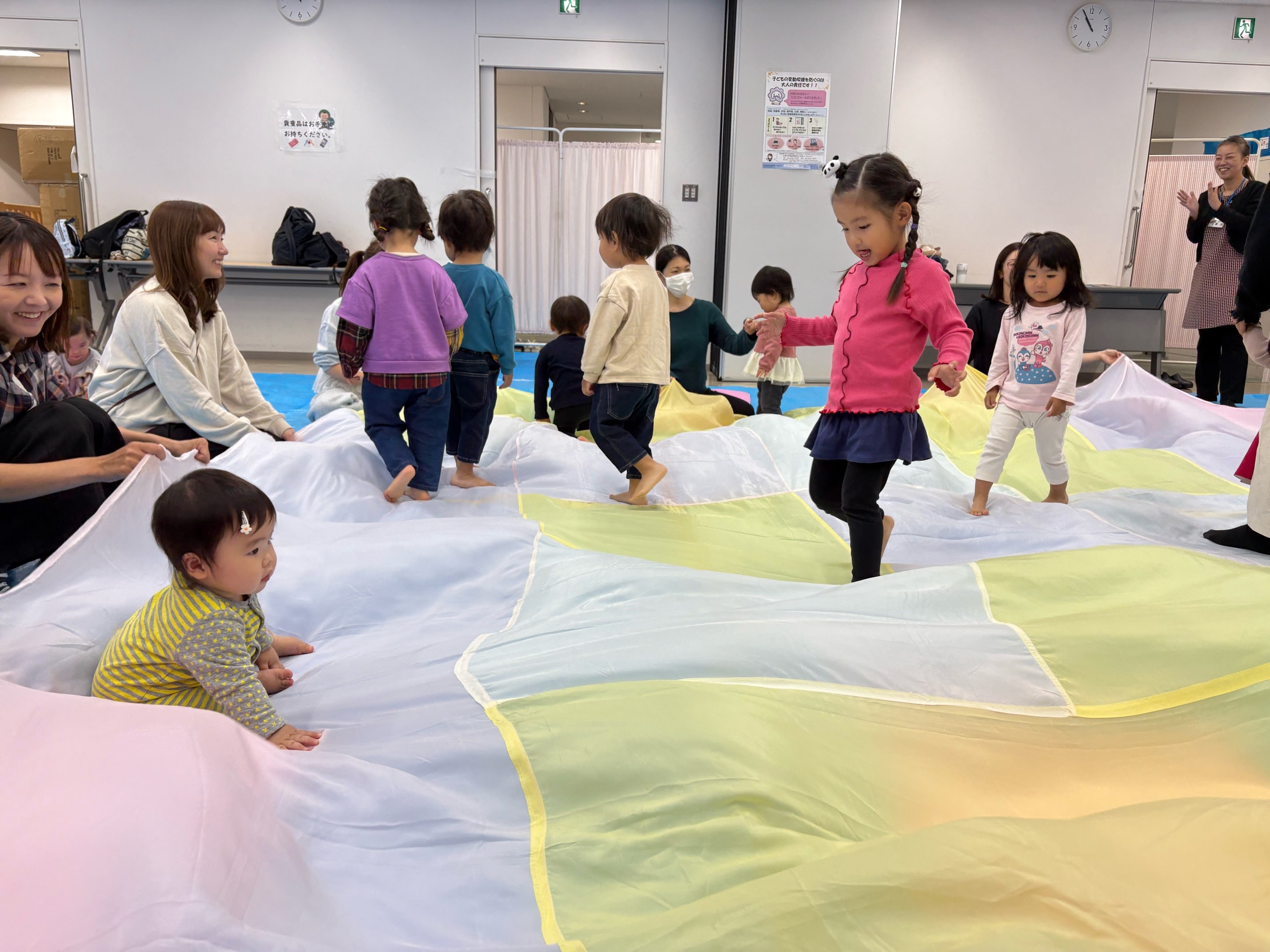 大きな布の上で遊んでいる子どもたち