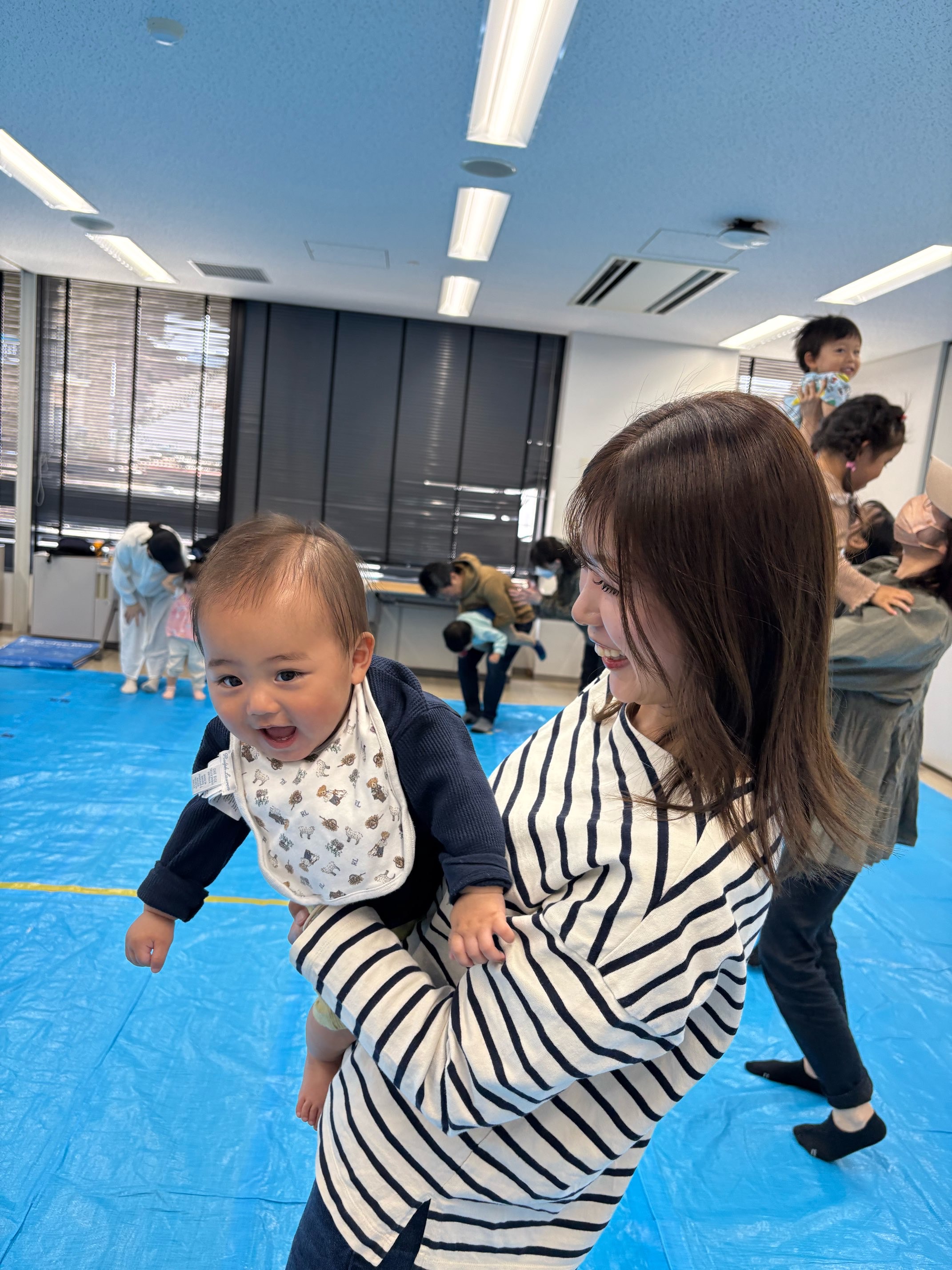 ママに抱っこしてもらい笑顔のこども