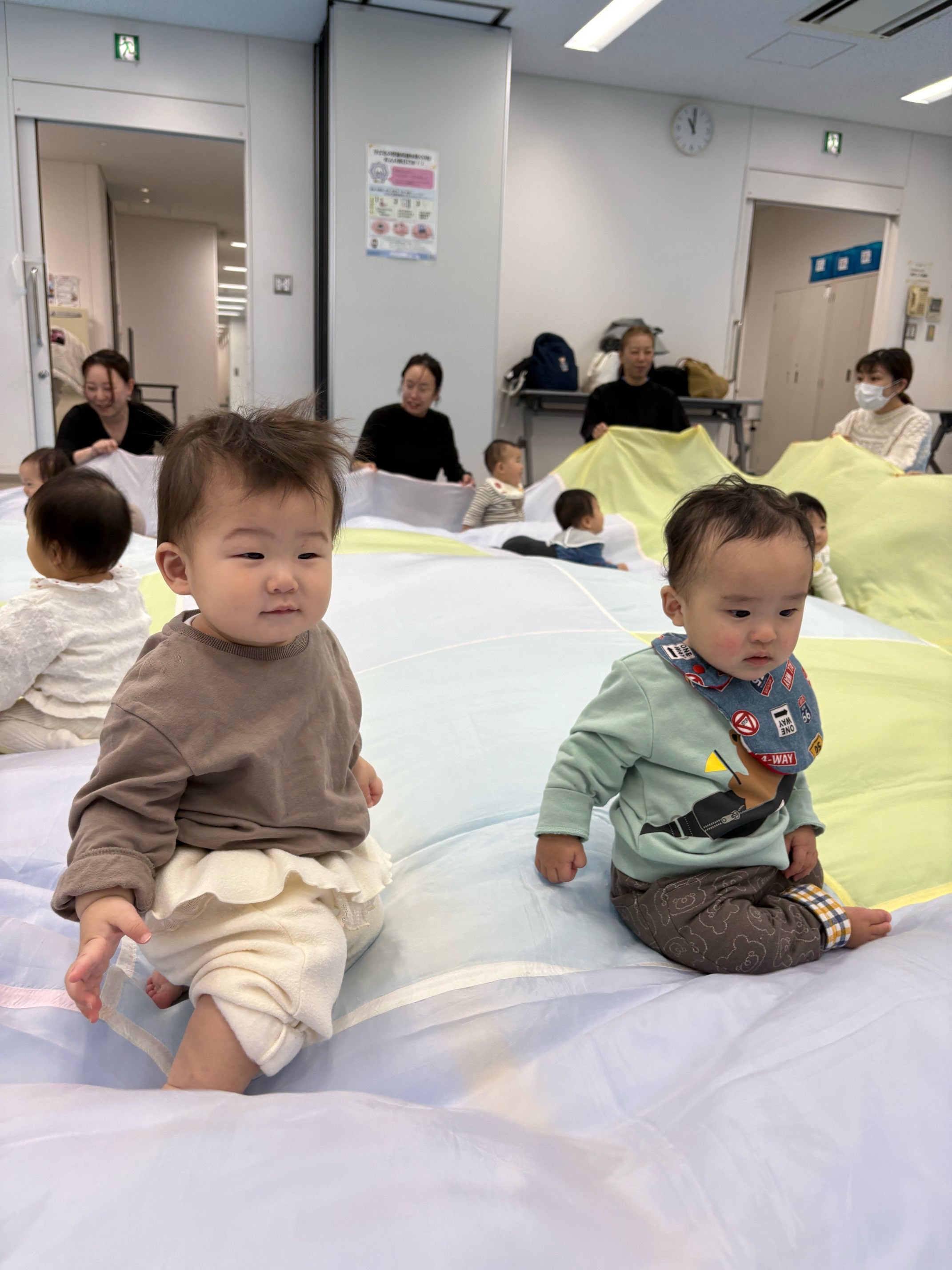 大きな布の上で遊んでいる子どもたち