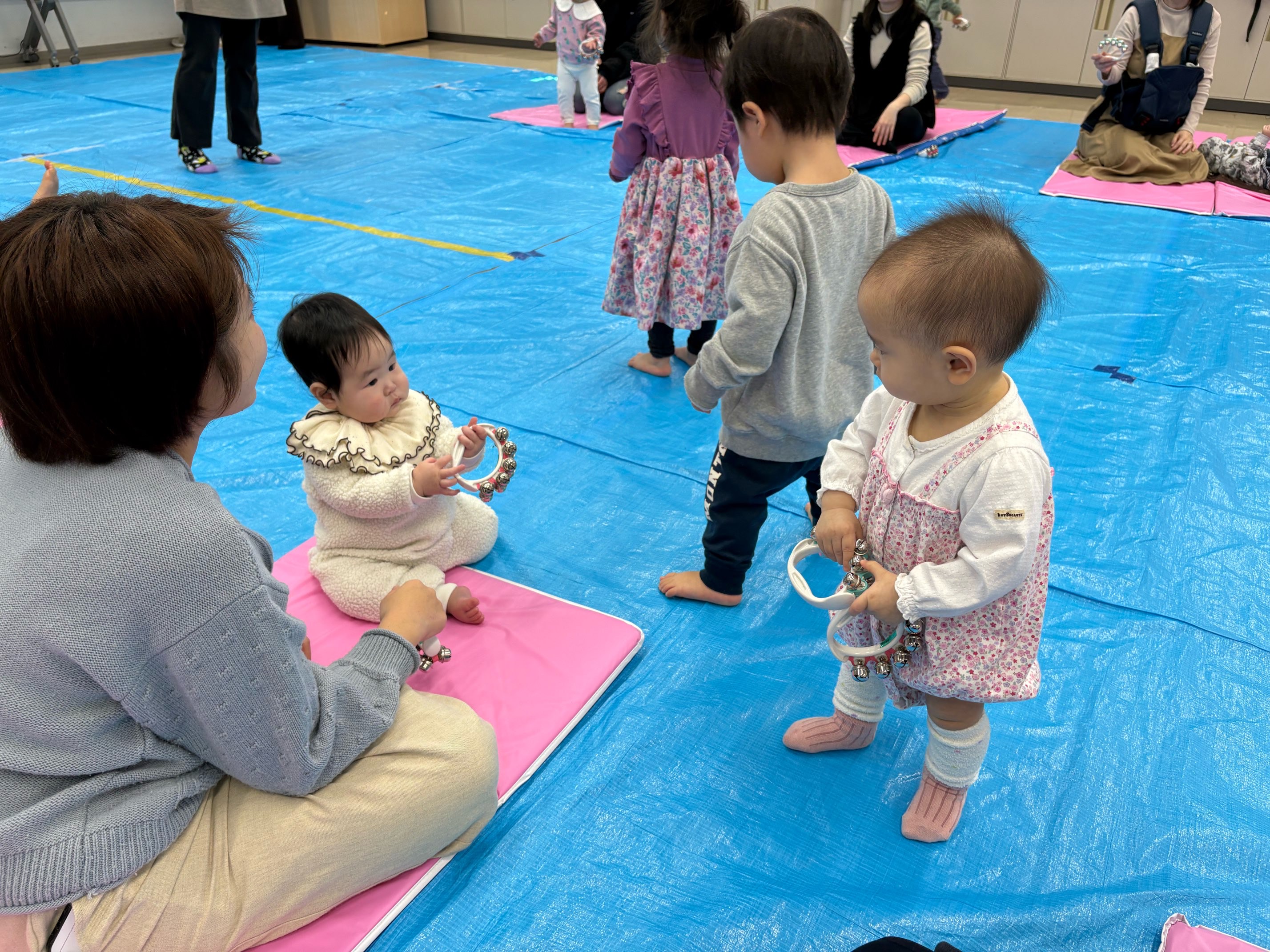 自分の鈴を見せあいっこしている2人の子ども