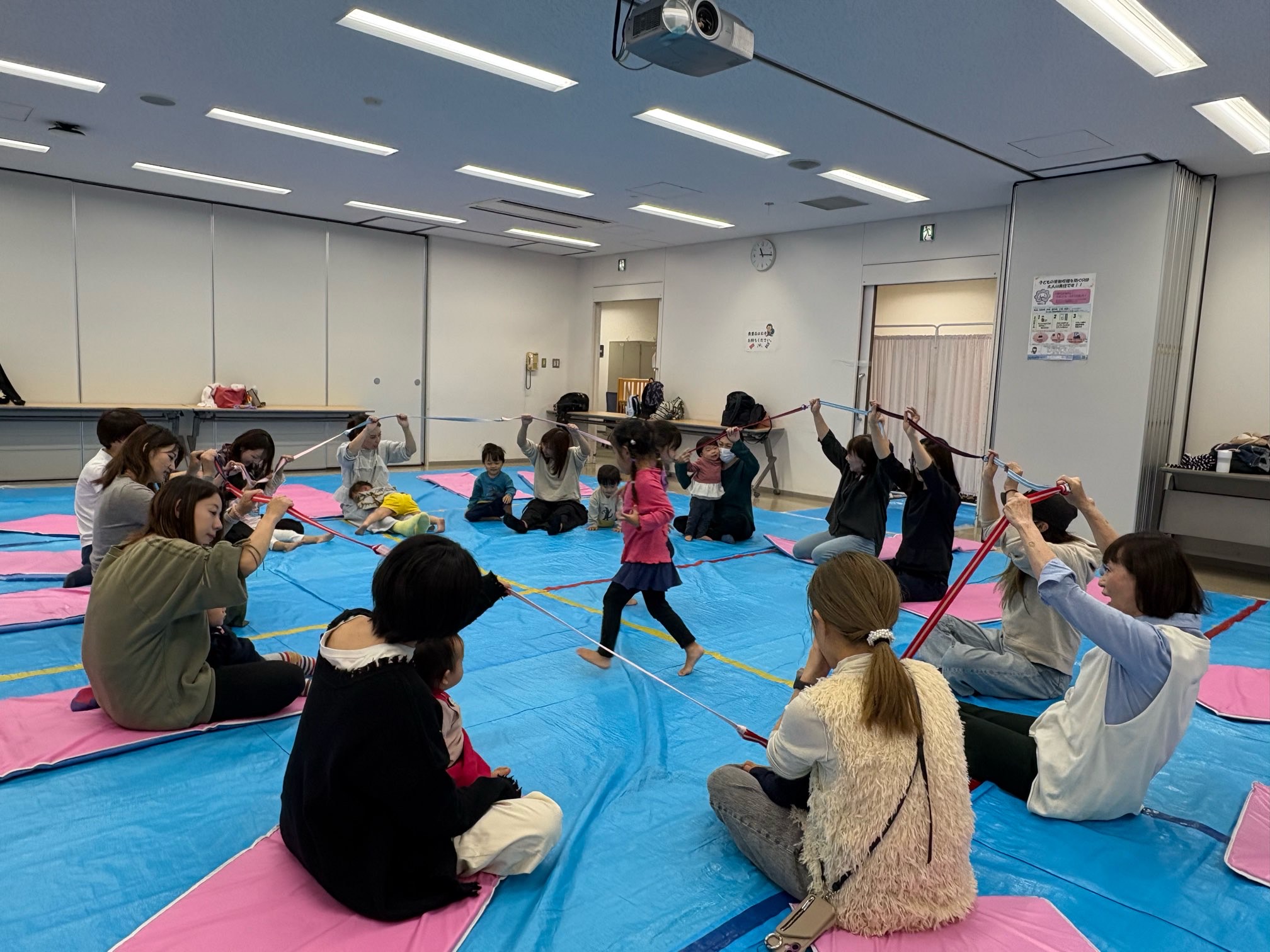 みんなで輪になって遊んでいる親子