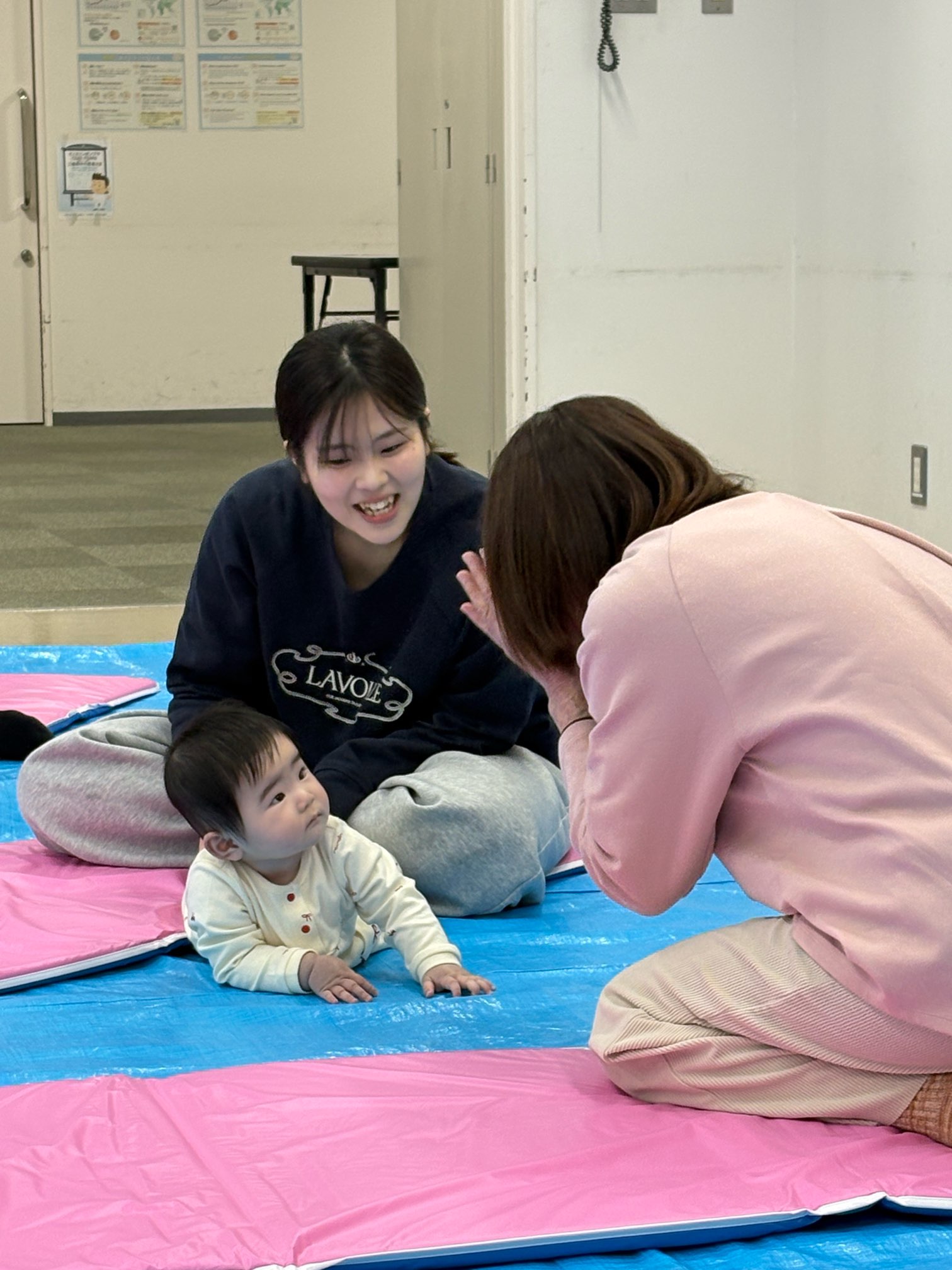 音楽に合わせて、いないいないばあ遊びを楽しんでいる親子