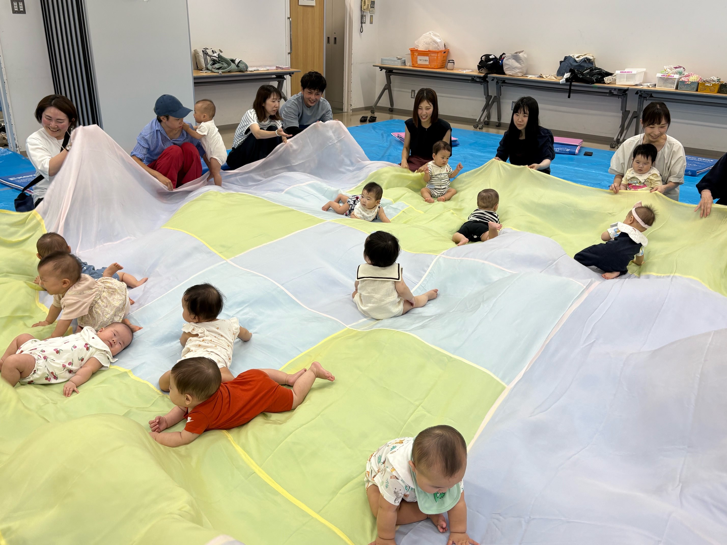 大きな布の上で遊んでいる子どもたち