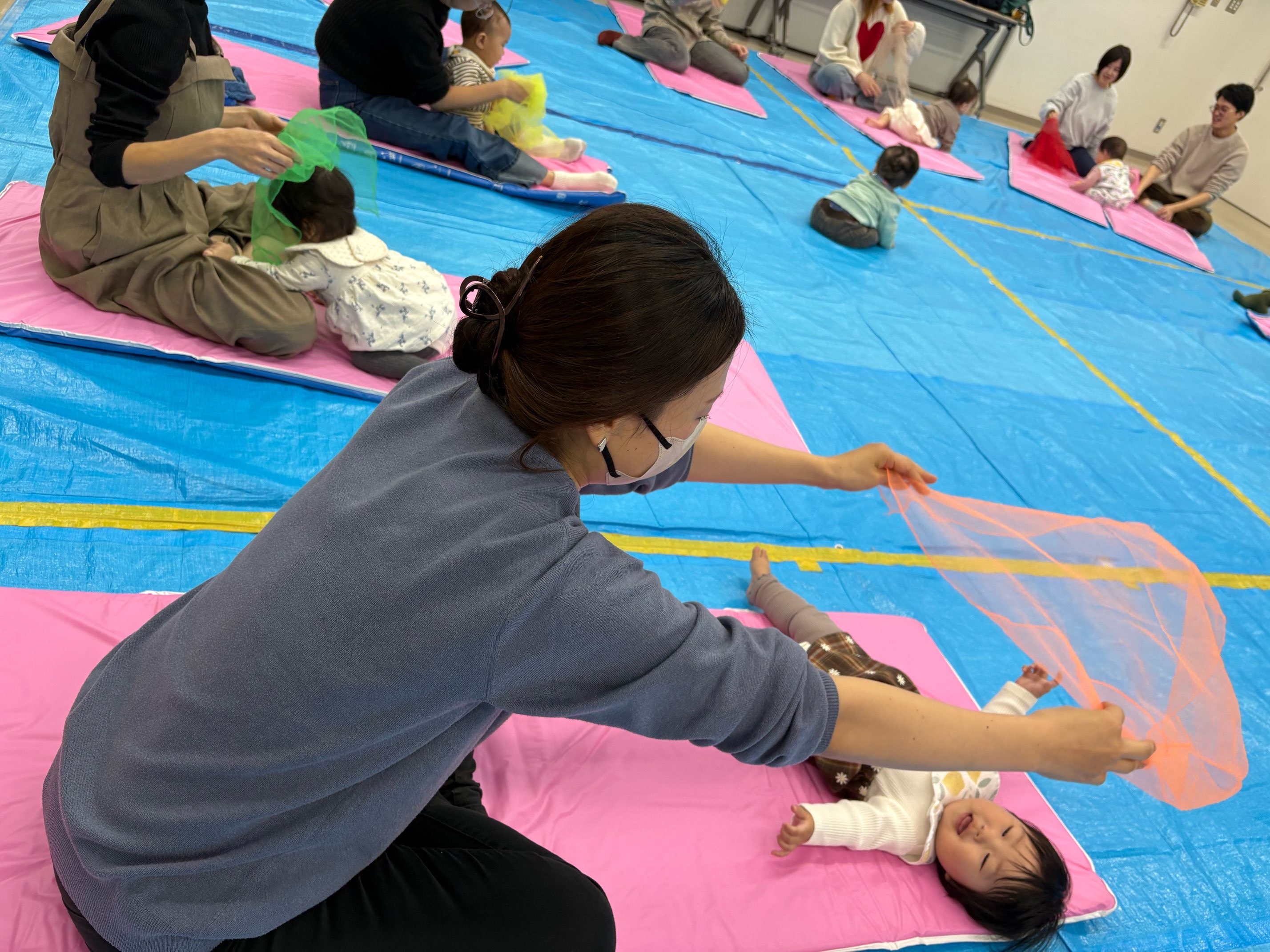 布を使ってあそんでいる親子