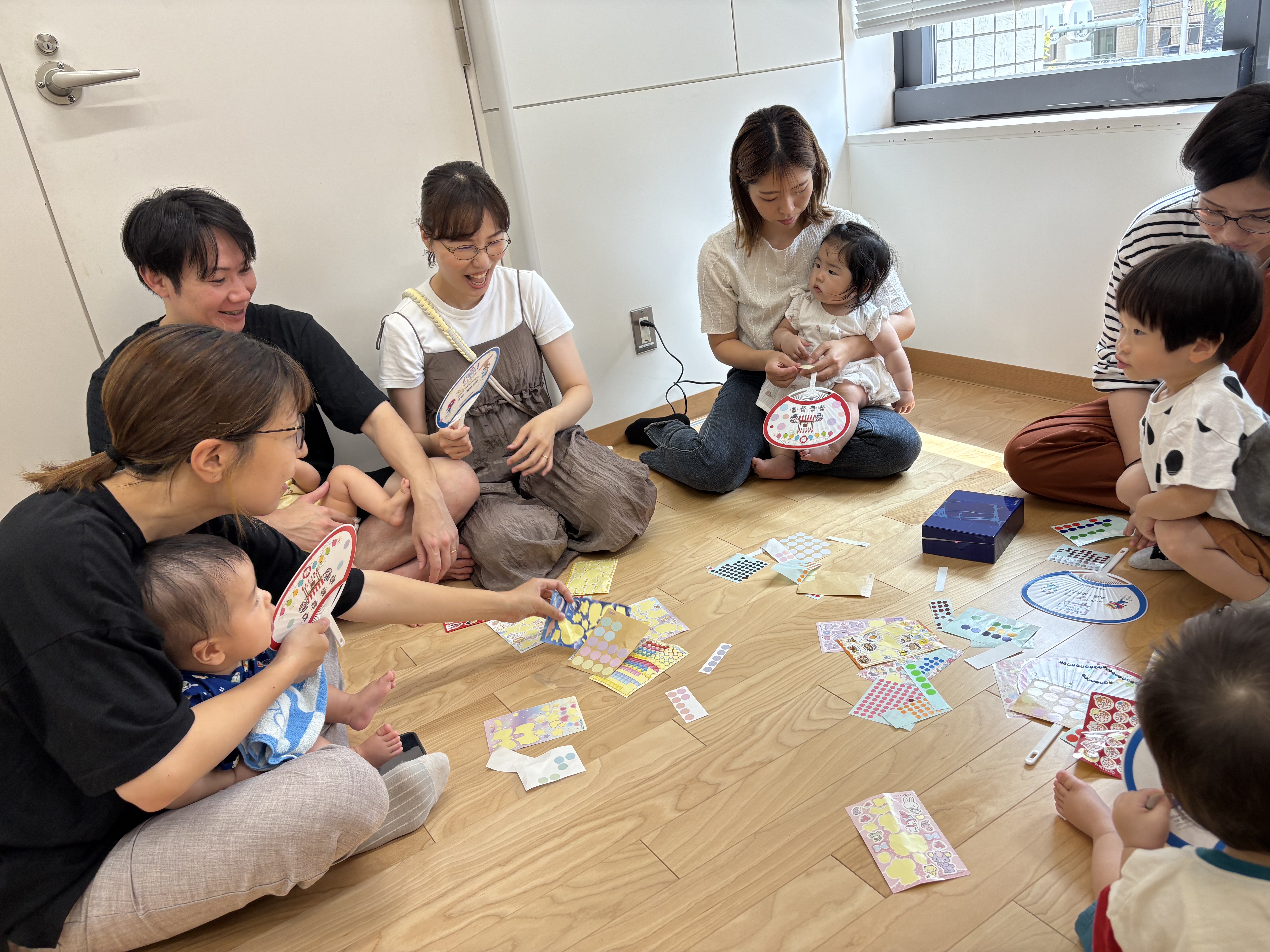 うちわのシール貼り制作をしている親子