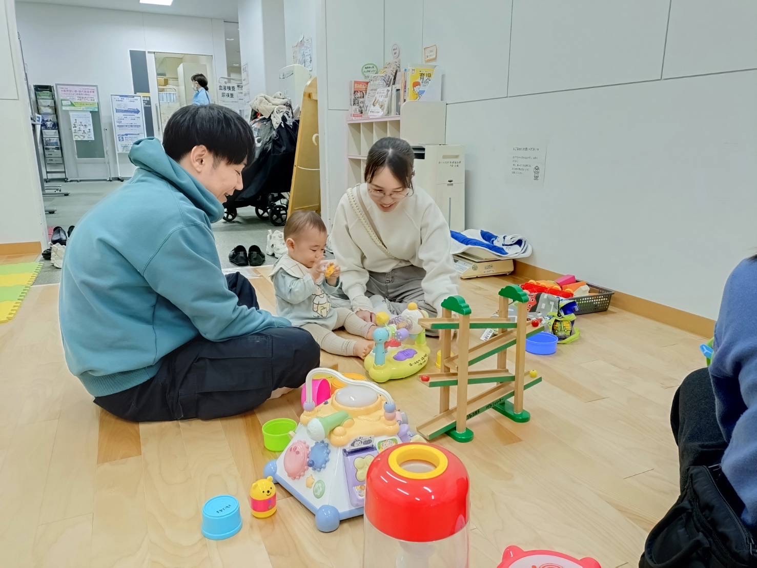 おもちゃで遊んでいる父母と子