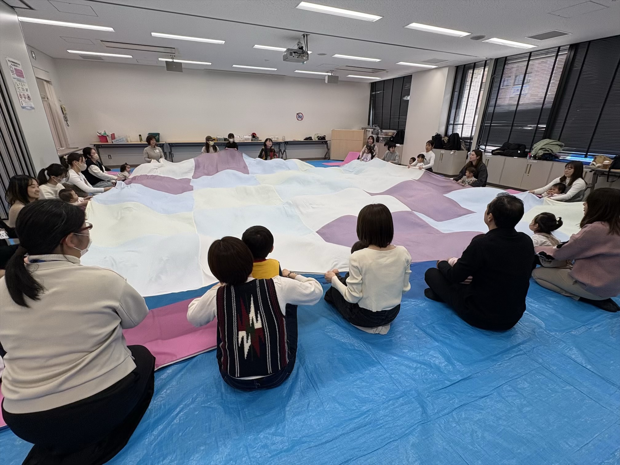 大きな布で遊んでいる親子