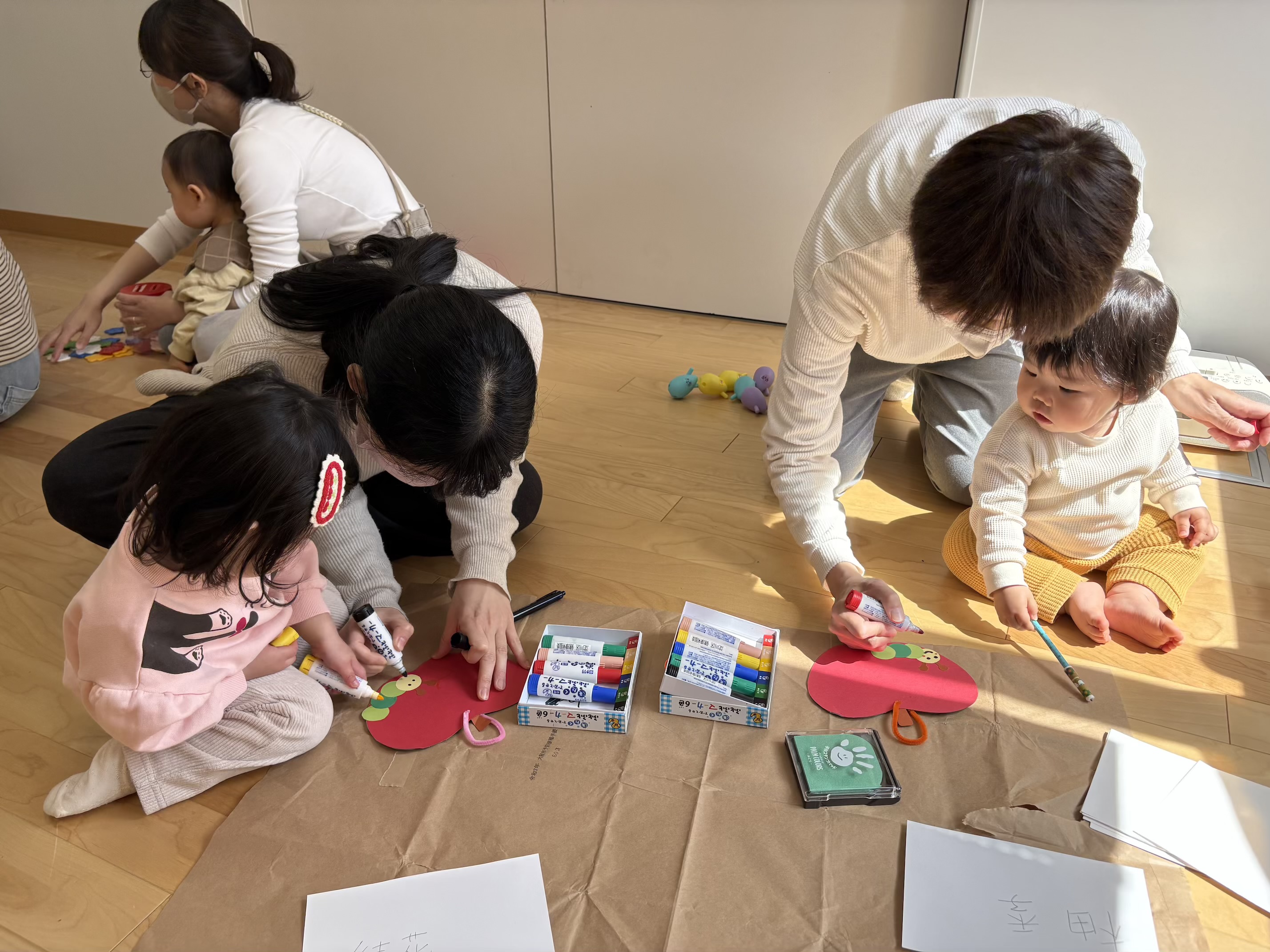 あおむしの顔を描いている親子