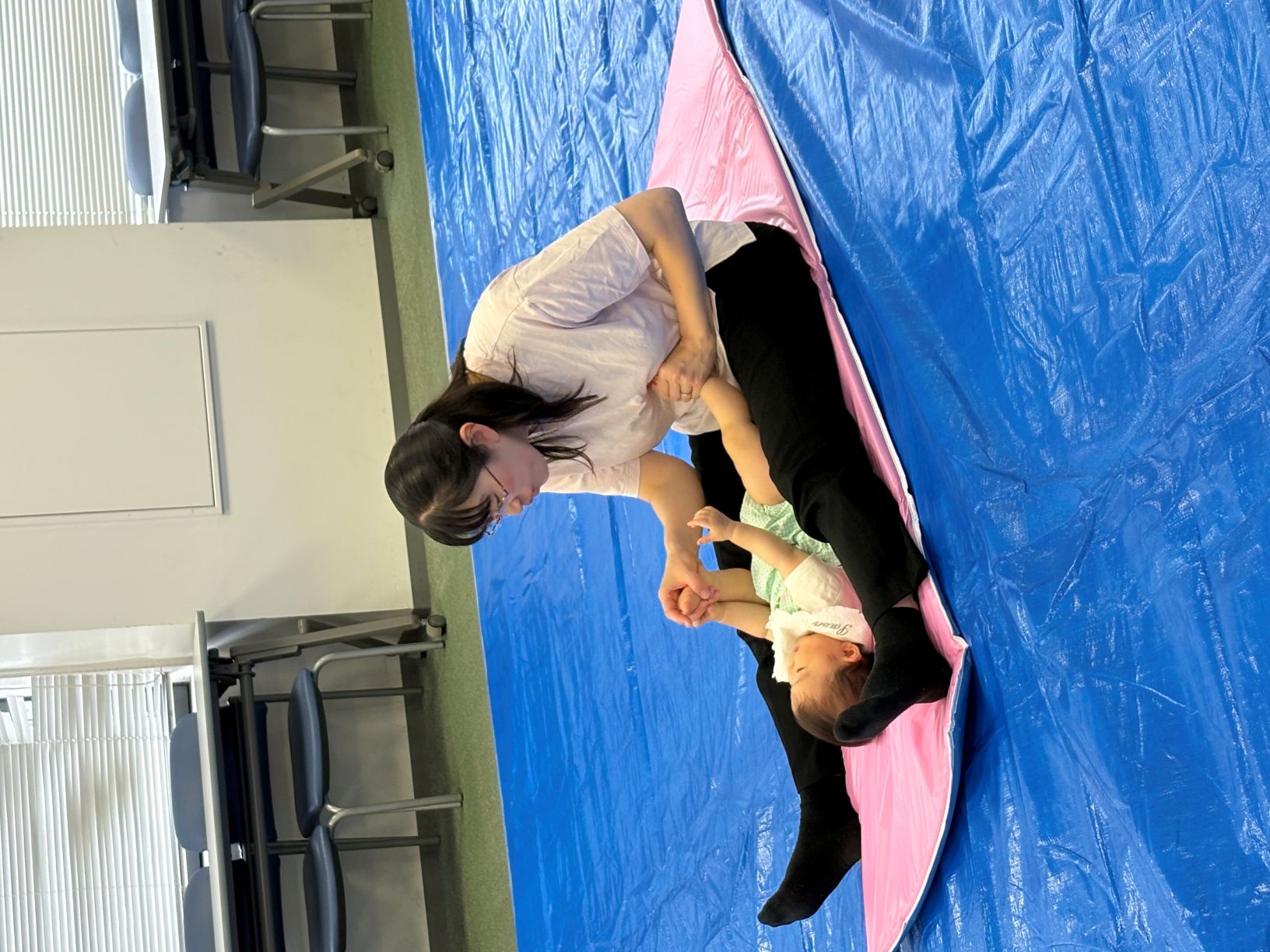 子どもの足を持ってふれあいをしている母