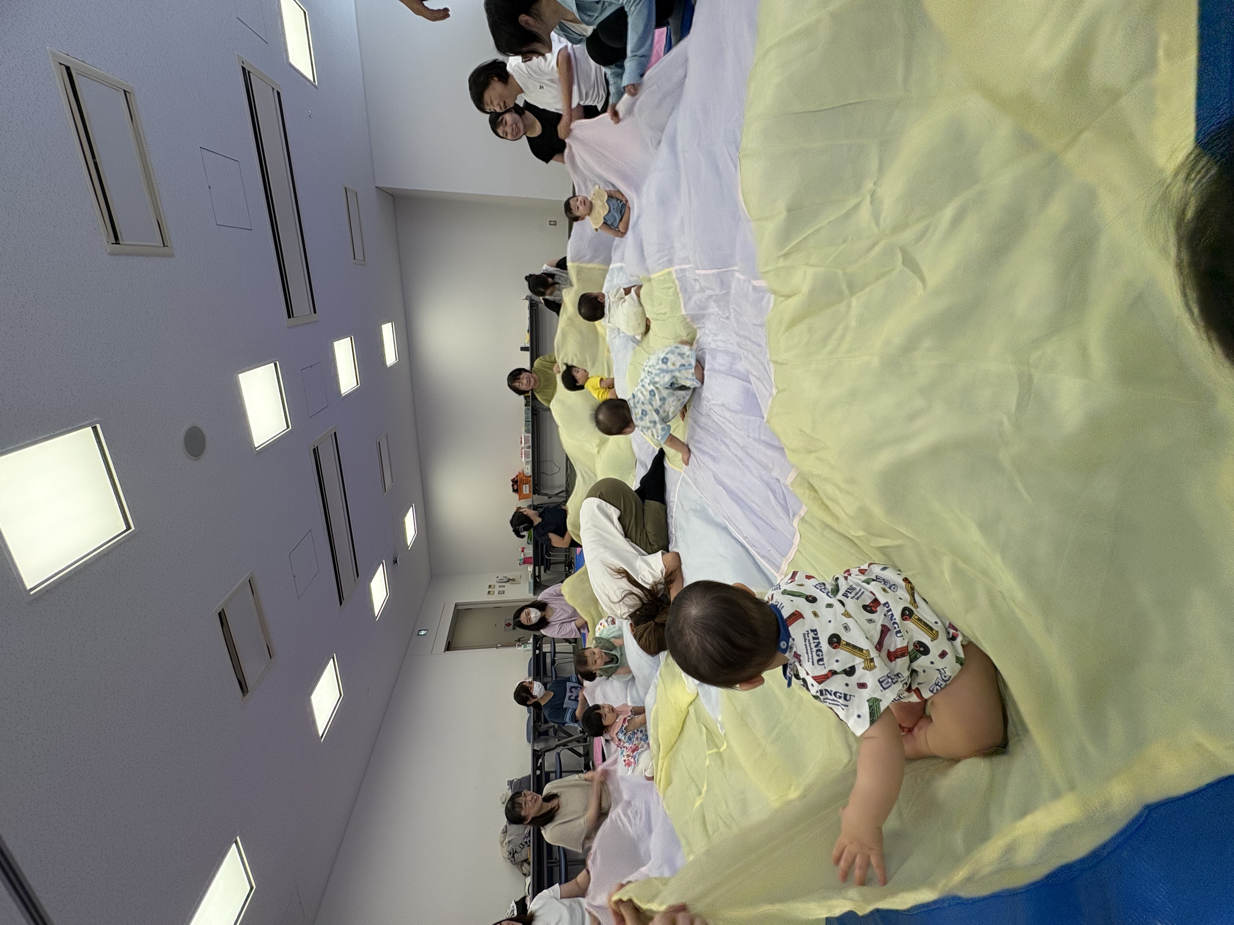 大きな布の上で遊んでいる子どもたち