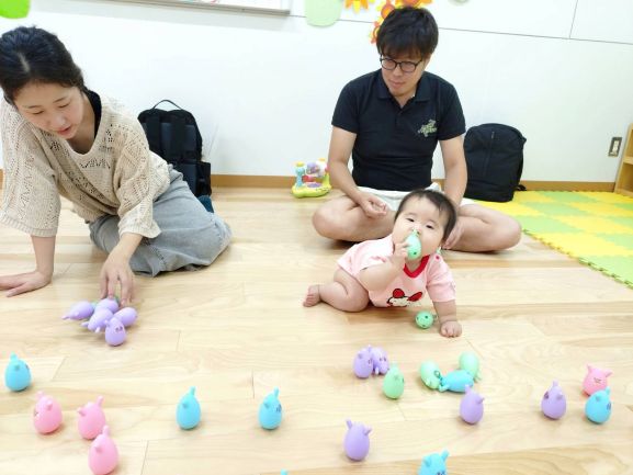 おもちゃで遊んでいる父母と子ども