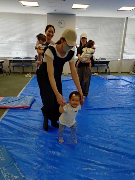 手を繋いだり、子どもを抱っこして音楽に合わせて歩いている親子