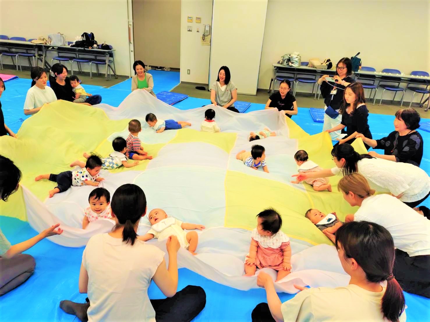 大きな布で遊んでいる親子